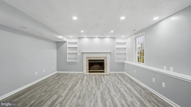 a view of an empty room with a fireplace and a window