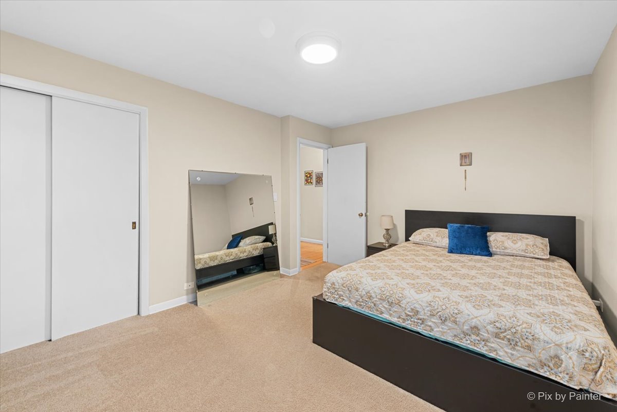 431 North Melrose Avenue Elgin, IL 60123 - Photo 9 of 32 a bedroom with a large bed and a chandelier