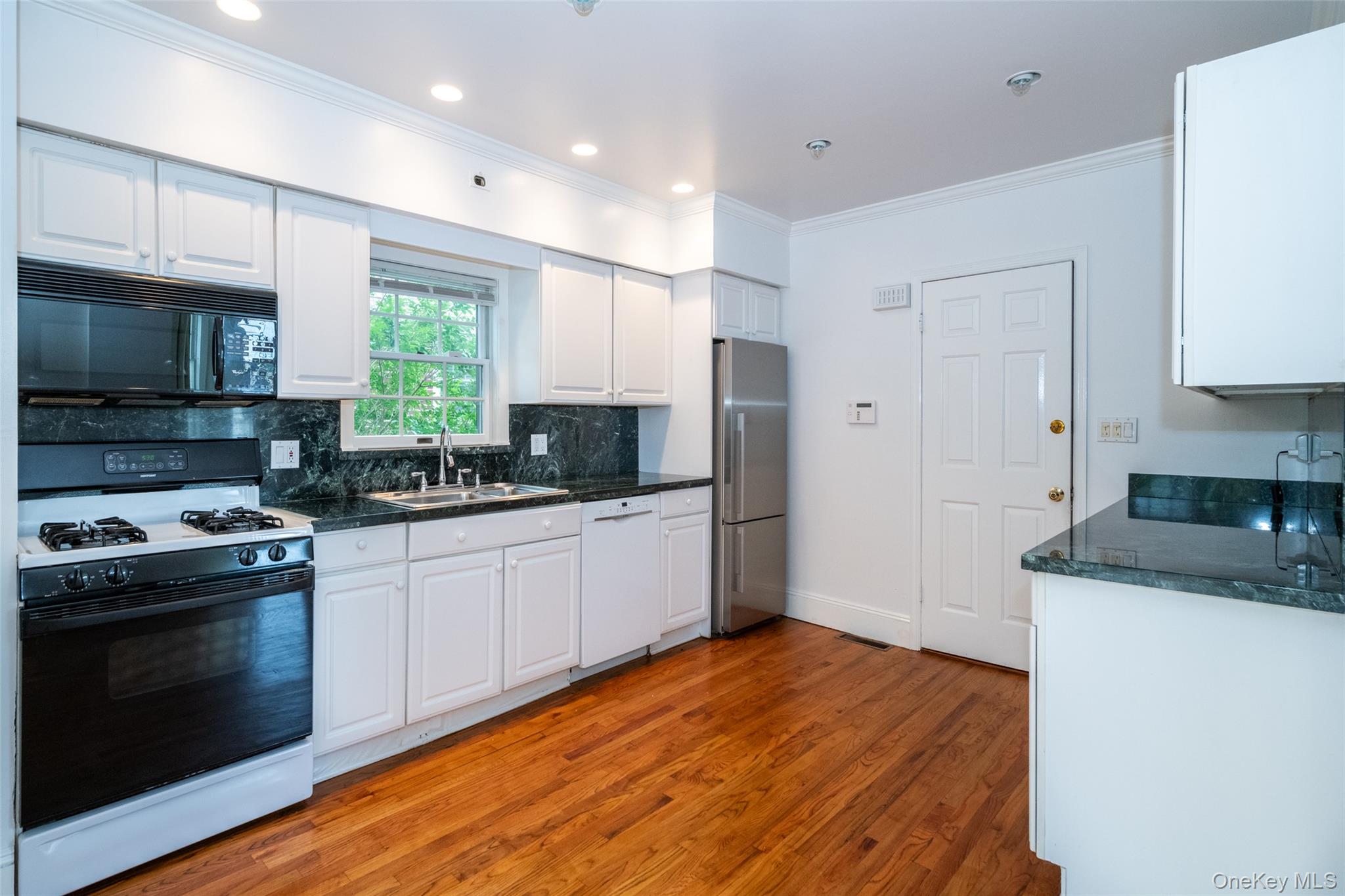 82 Clove Road New Rochelle, NY 10801 - Photo 3 of 39 a kitchen with stainless steel appliances granite countertop a stove a sink and a refrigerator