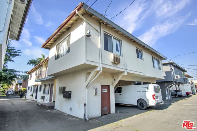 a car parked in front of a white house