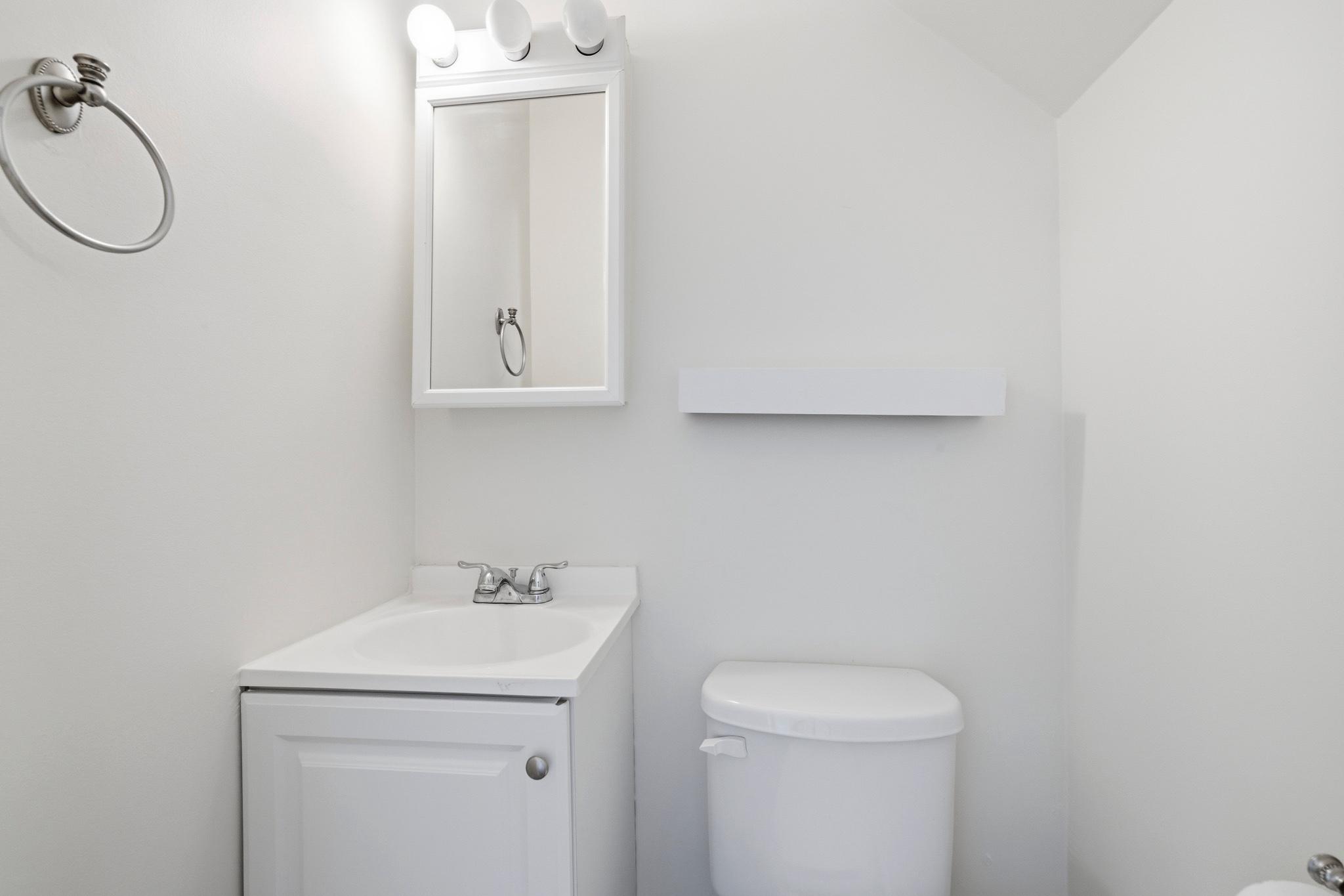 925 8th Street Northeast Washington, DC 20002 - Photo 12 of 24 a bathroom with a granite countertop sink a toilet and a mirror