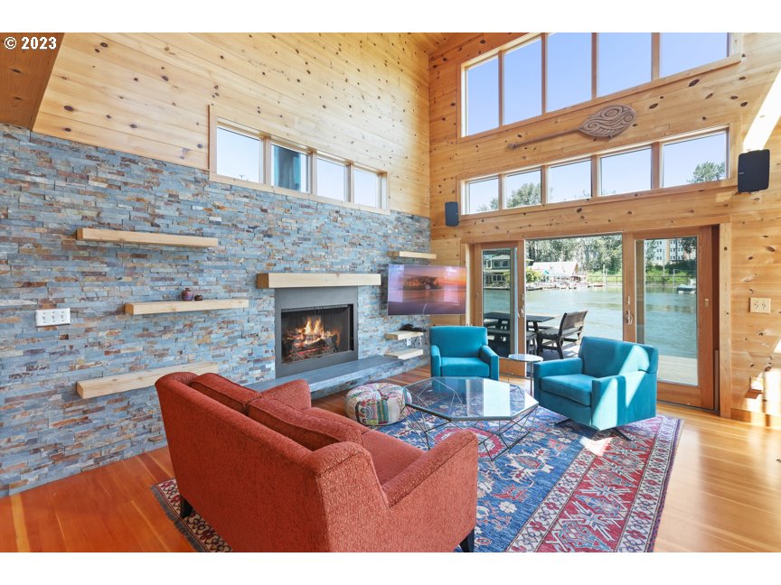 111 North Bridgeton Road, Unit E05 Portland, OR 97217 - Photo 15 of 42 a living room with furniture a fireplace and a flat screen tv