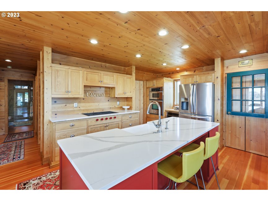 111 North Bridgeton Road, Unit E05 Portland, OR 97217 - Photo 21 of 42 a kitchen with stainless steel appliances kitchen island granite countertop a table chairs sink and cabinets