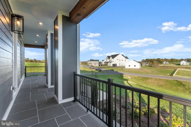 an empty room with wooden floor a ceiling fan and windows
