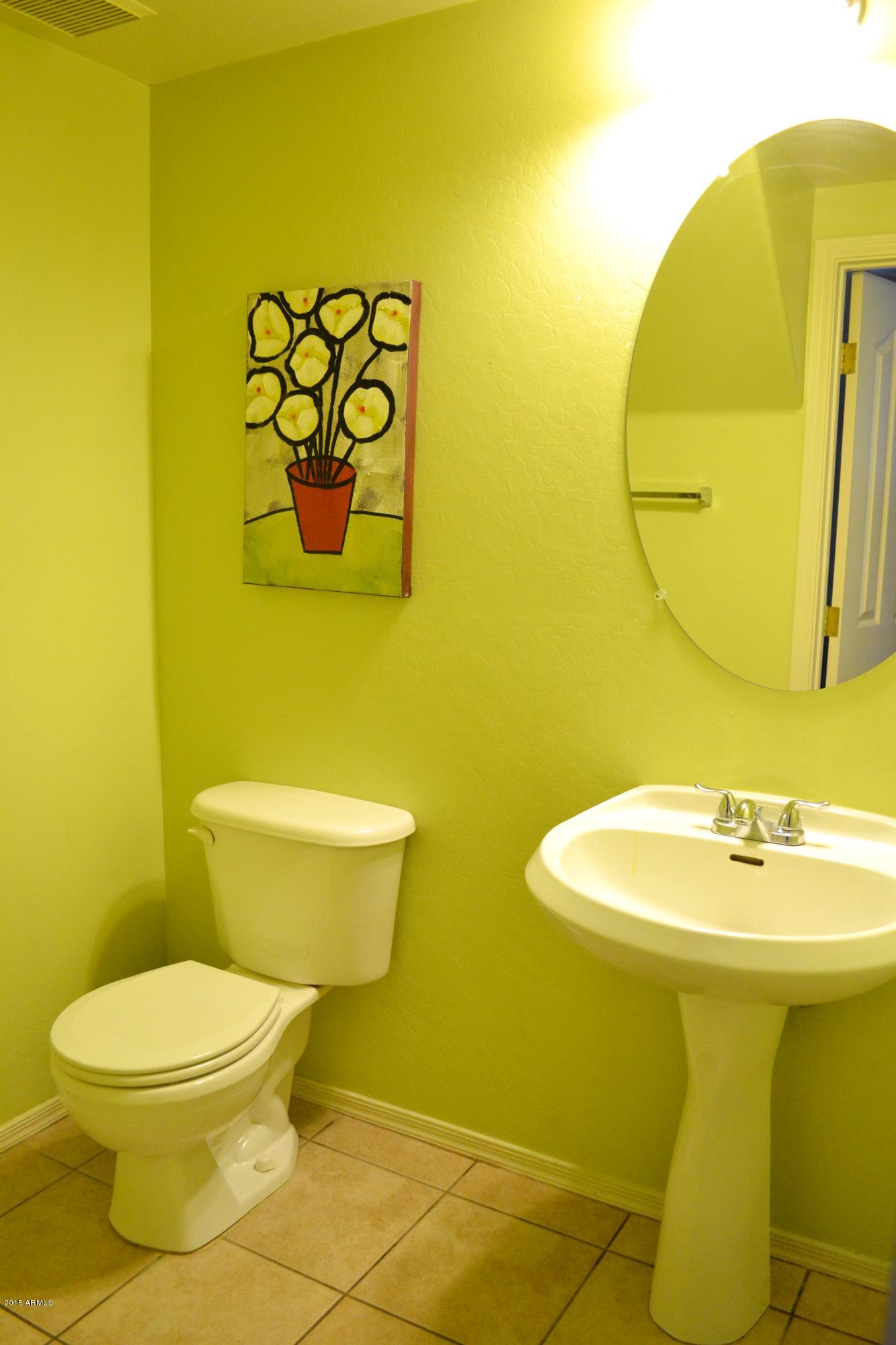 3906 West Carter Road Phoenix, AZ 85041 - Photo 14 of 32 a bathroom with a toilet sink and mirror