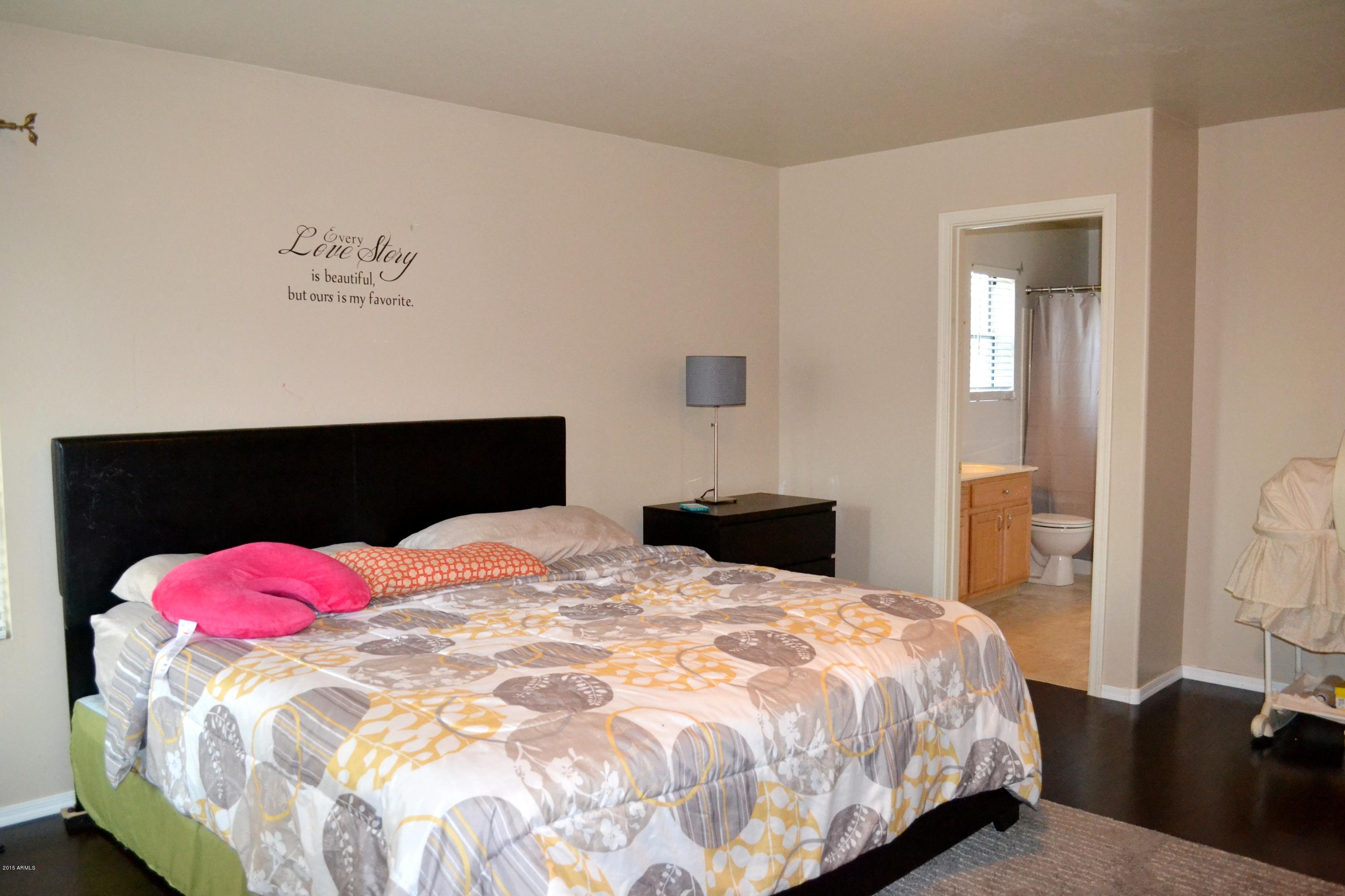 3906 West Carter Road Phoenix, AZ 85041 - Photo 20 of 32 a bedroom with a bed and wooden floor