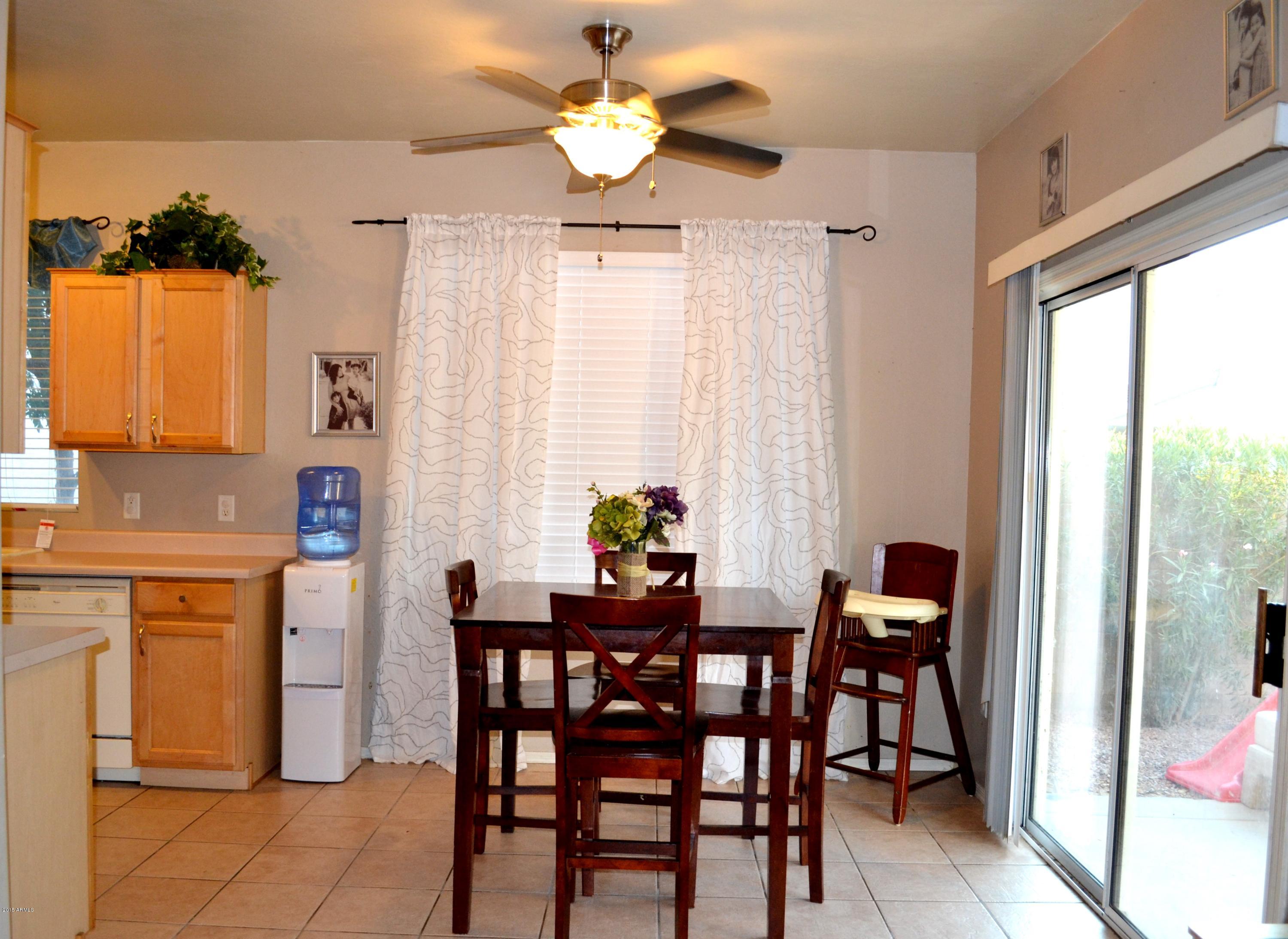 3906 West Carter Road Phoenix, AZ 85041 - Photo 8 of 32 a dining room with furniture a chandelier and a window