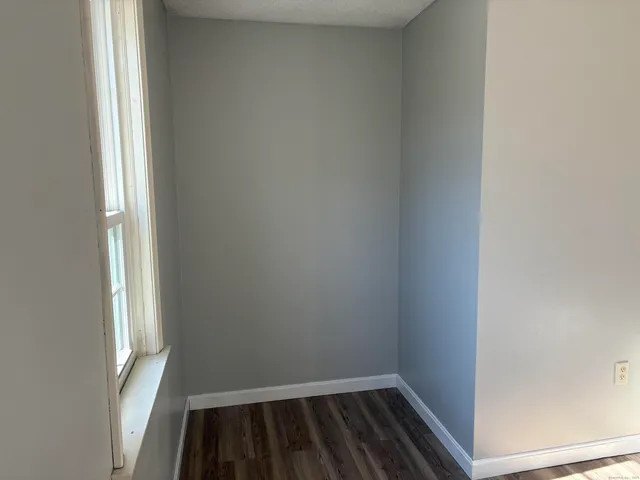 a view of a room with wooden floor and a window