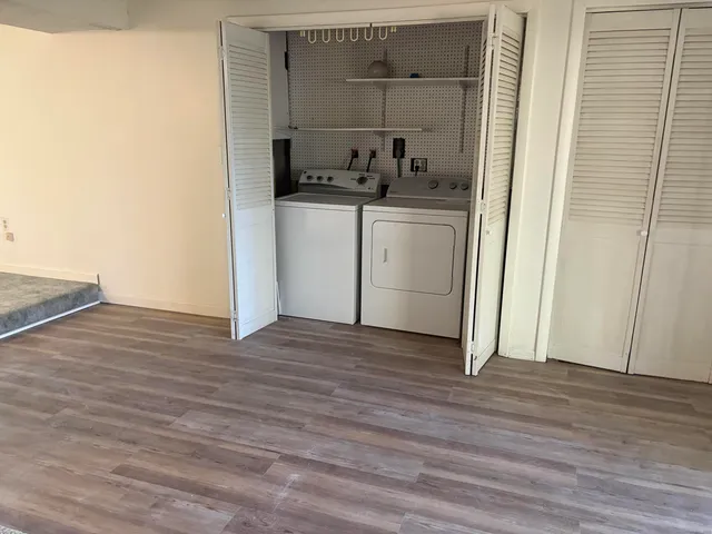 a view of a kitchen from the hallway with a wooden floor