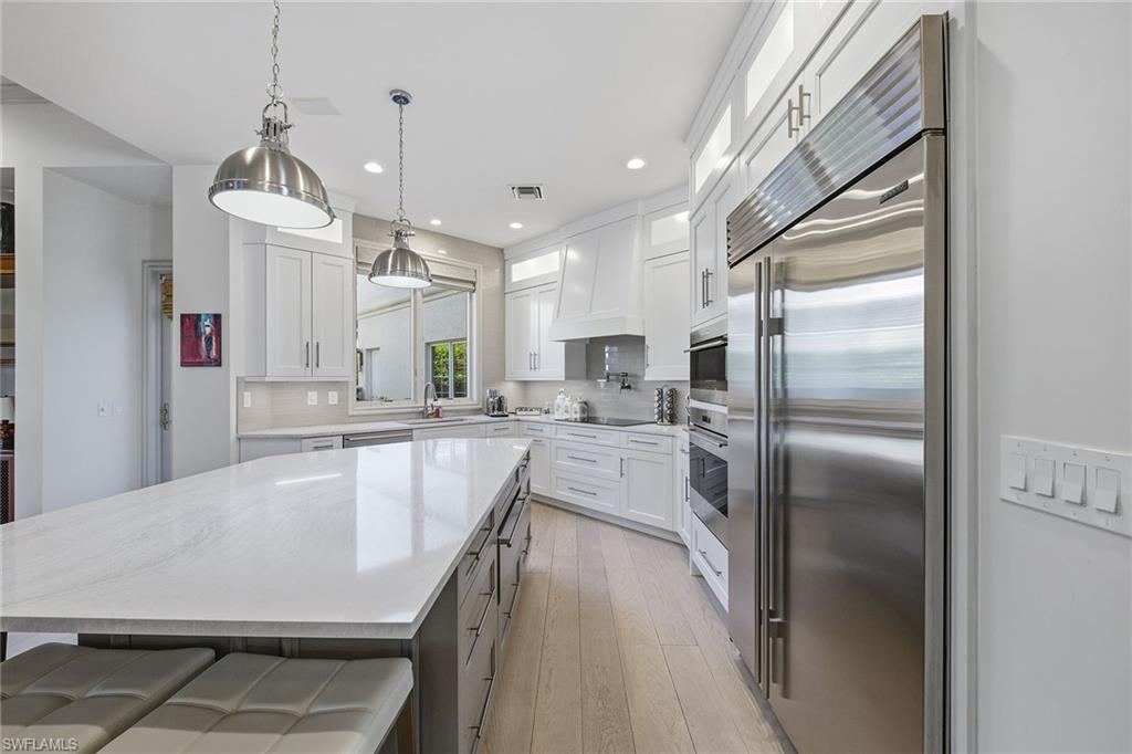 355 Sedgwick Court Naples, FL 34108 - Photo 13 of 48 a kitchen with kitchen island a counter top space a sink stainless steel appliances and cabinets
