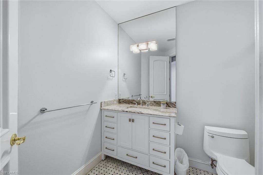 355 Sedgwick Court Naples, FL 34108 - Photo 21 of 48 a bathroom with a granite countertop toilet sink and mirror