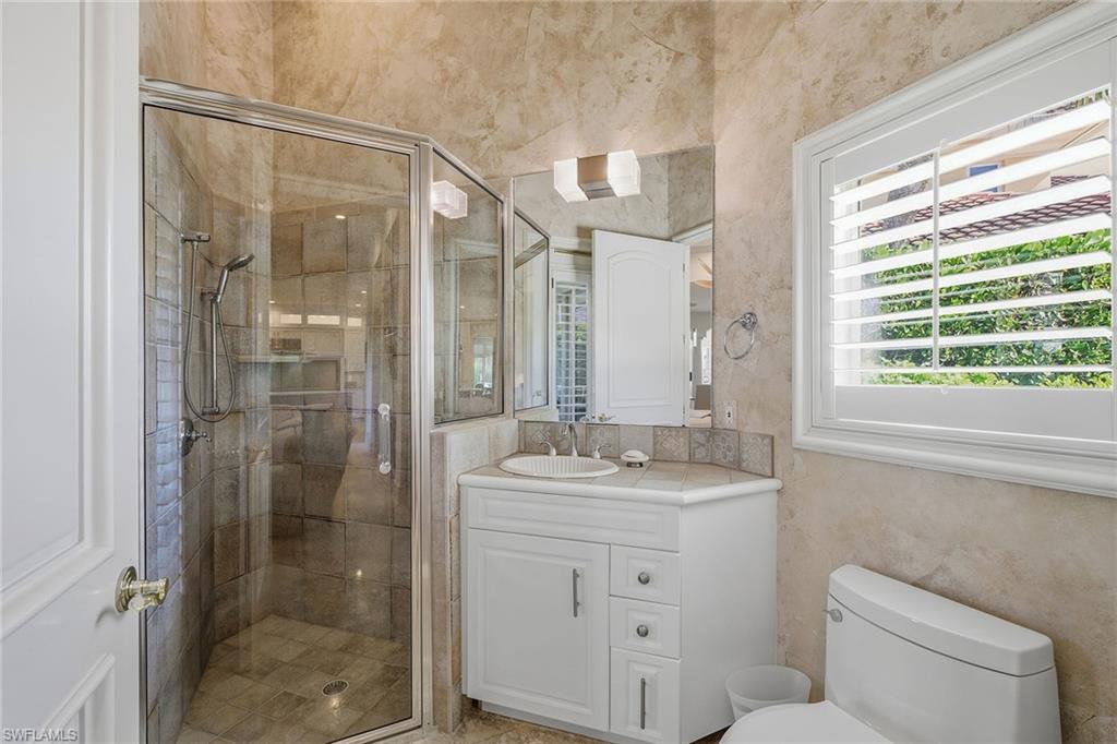 355 Sedgwick Court Naples, FL 34108 - Photo 27 of 48 a bathroom with a shower sink vanity mirror and toilet