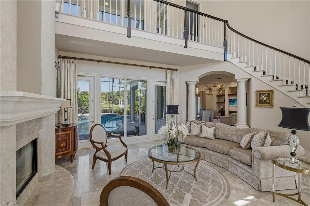 355 Sedgwick Court Naples, FL 34108 - Photo 5 of 48 a living room with furniture a fireplace and a large window