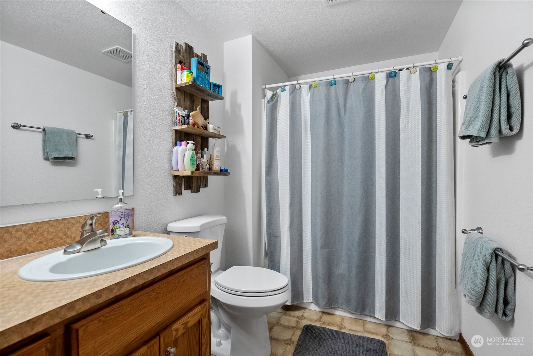 5520 133rd Avenue Southwest Rochester, WA 98579 - Photo 29 of 40 a bathroom with a sink a toilet and shower curtain