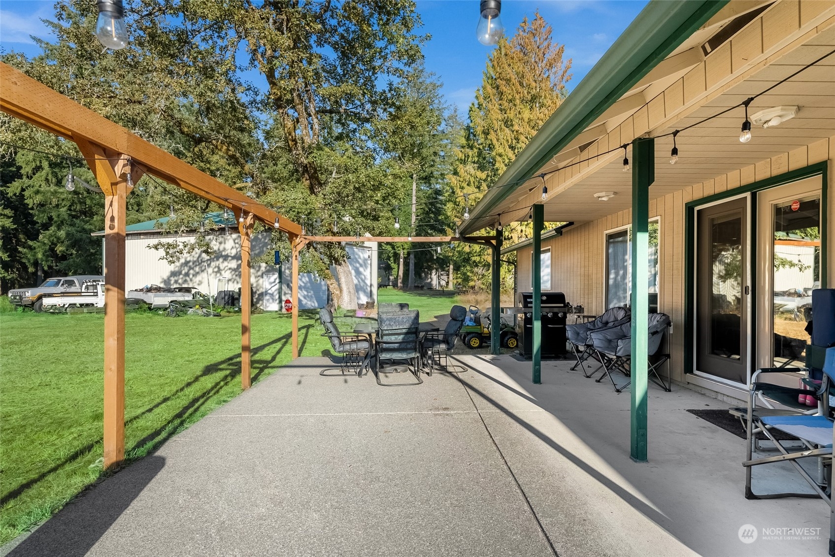 5520 133rd Avenue Southwest Rochester, WA 98579 - Photo 35 of 40 a view of a patio with table and chairs floor to ceiling window with wooden fence