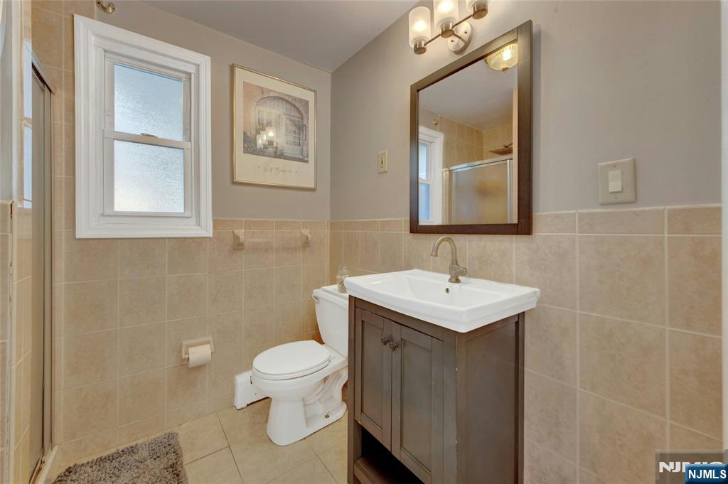 683 Eastern Court Ridgewood, NJ 07450 - Photo 16 of 25 a bathroom with a toilet a sink a mirror and a window