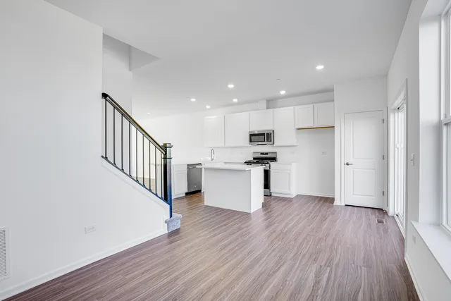 a view of kitchen with wooden floor and electronic appliances