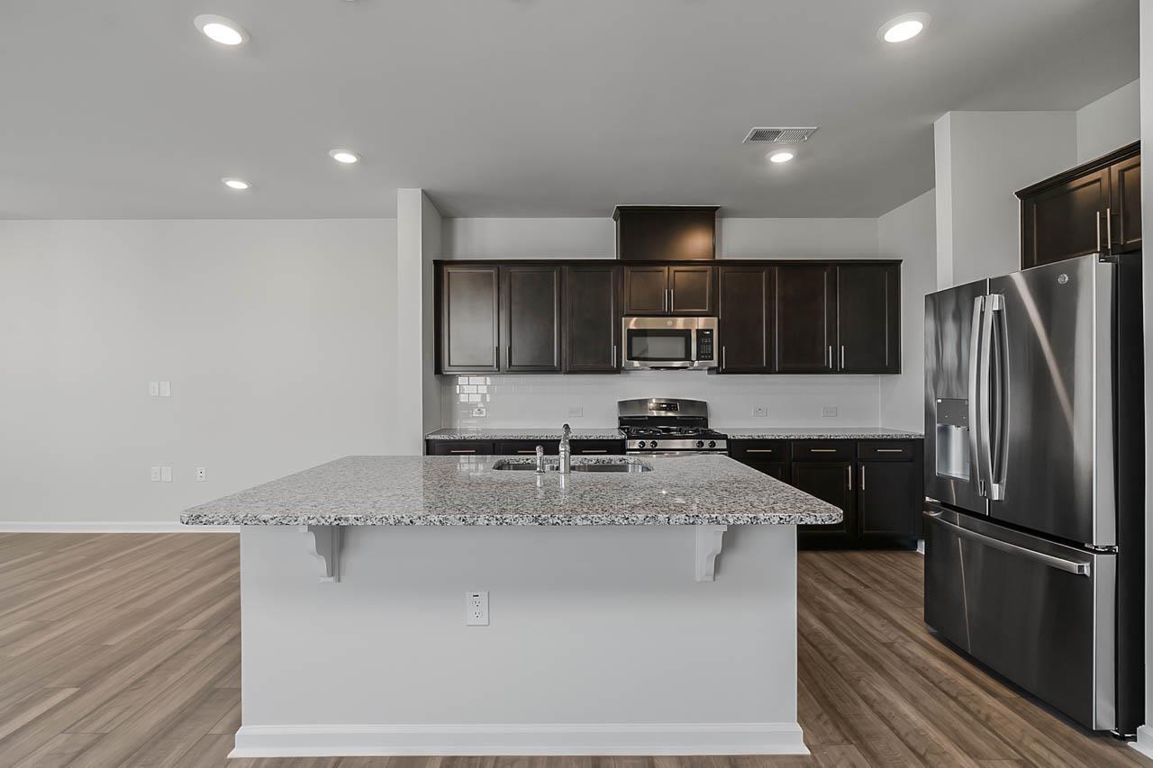 2421 Chert Lane Raleigh, NC 27610 - Photo 18 of 97 a kitchen with stainless steel appliances granite countertop a refrigerator a stove and a sink with wooden cabinets