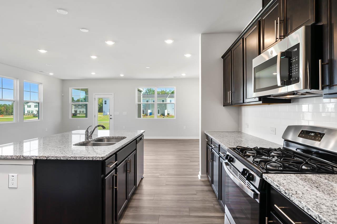 2421 Chert Lane Raleigh, NC 27610 - Photo 20 of 97 a kitchen with stainless steel appliances granite countertop a sink stove and microwave