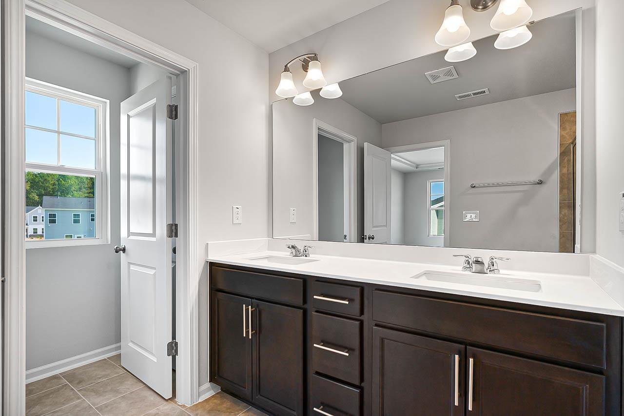 2421 Chert Lane Raleigh, NC 27610 - Photo 32 of 97 a bathroom with a sink a large mirror and a light fixture