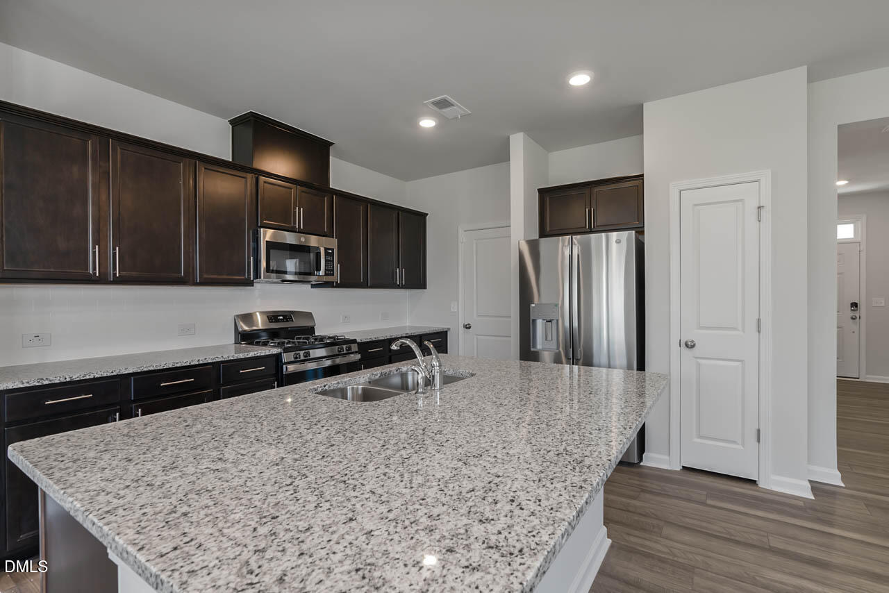 2421 Chert Lane Raleigh, NC 27610 - Photo 77 of 97 a kitchen with stainless steel appliances granite countertop a sink refrigerator and microwave