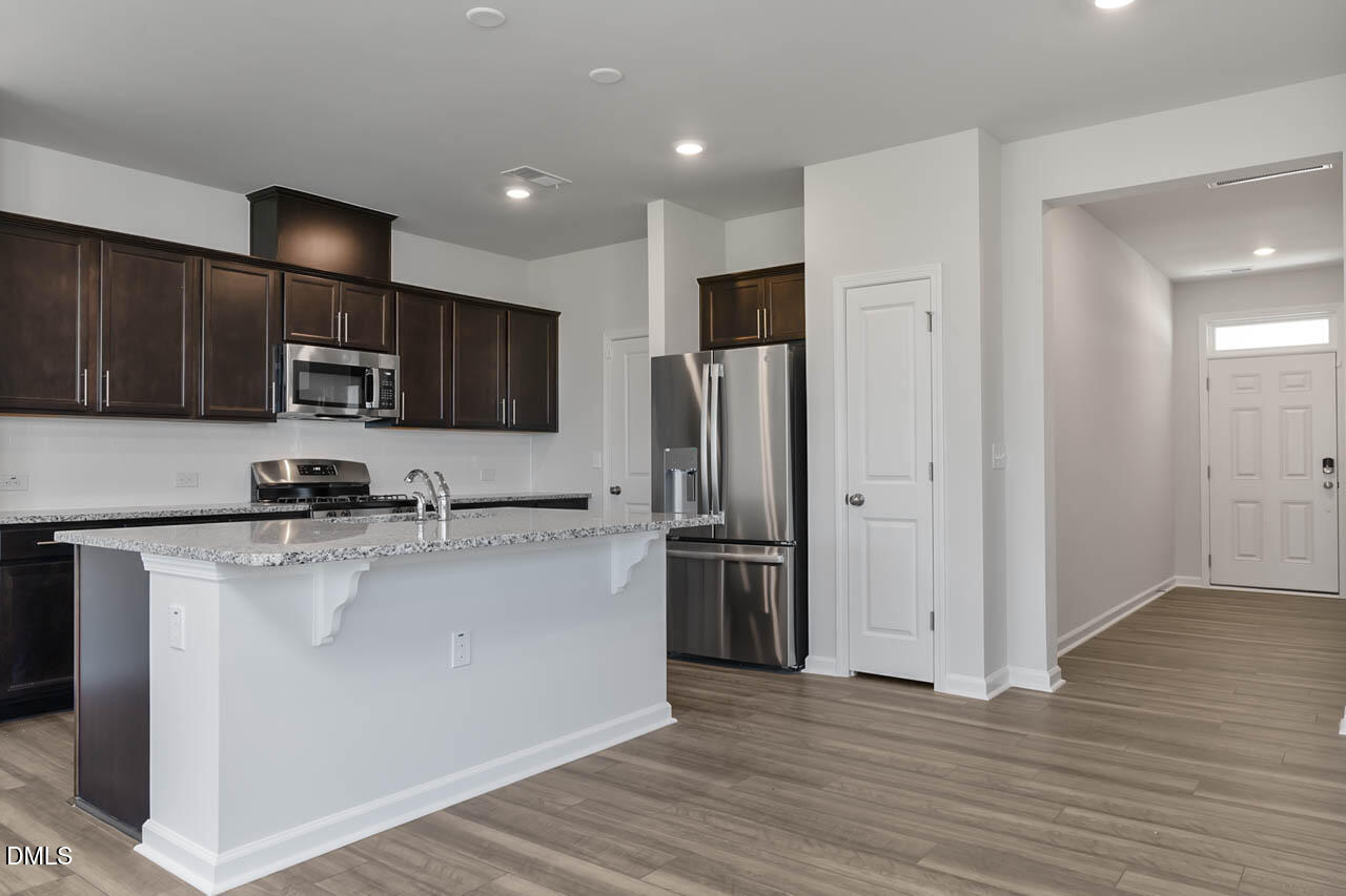 2421 Chert Lane Raleigh, NC 27610 - Photo 85 of 97 a kitchen with stainless steel appliances granite countertop a refrigerator a sink a stove a microwave and cabinets