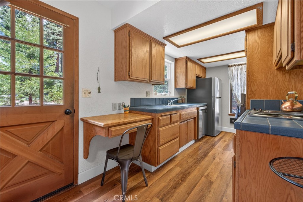 627 Cedar Canyon Road Lake Almanor, CA 96137 - Photo 9 of 34 a kitchen with stainless steel appliances granite countertop a refrigerator a sink dishwasher a stove and white countertops with wooden floor