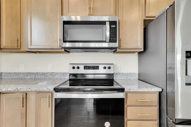 a kitchen with stainless steel appliances granite countertop a stove and a microwave