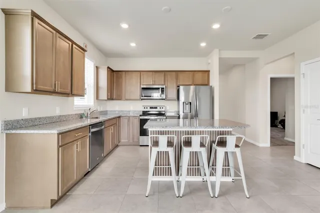 a kitchen with appliances a sink and cabinets