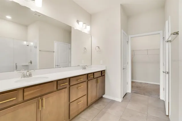 a bathroom with a double vanity sink and a mirror