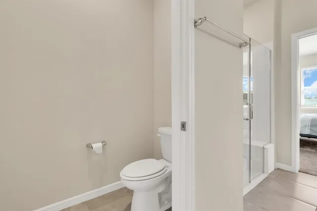 a bathroom with a toilet and a shower