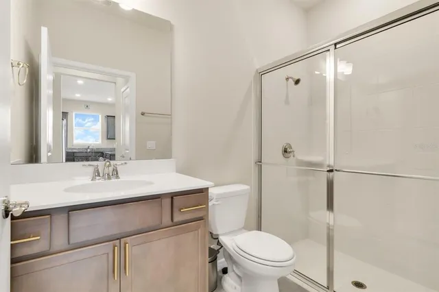 a bathroom with a sink toilet vanity and shower