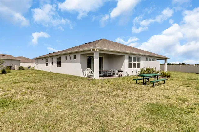 a view of a house with backyard porch and sitting area