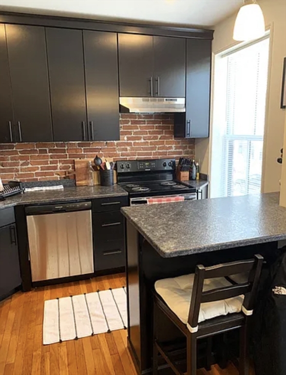 167 I Street, Unit 2 Boston, MA 02127 - Photo 4 of 9 a kitchen with stainless steel appliances granite countertop a sink stove and cabinets