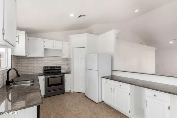 a kitchen with granite countertop a sink stainless steel appliances and cabinets