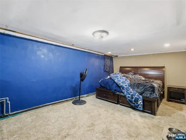 a spacious bedroom with a bed and a dresser