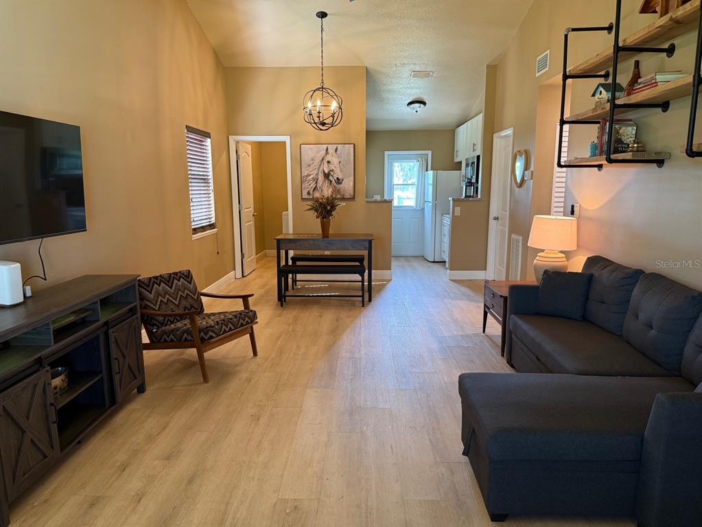 11248 Pendleton Avenue, Unit A&B Englewood, FL 34224 - Photo 4 of 15 a living room with furniture a flat screen tv and a refrigerator