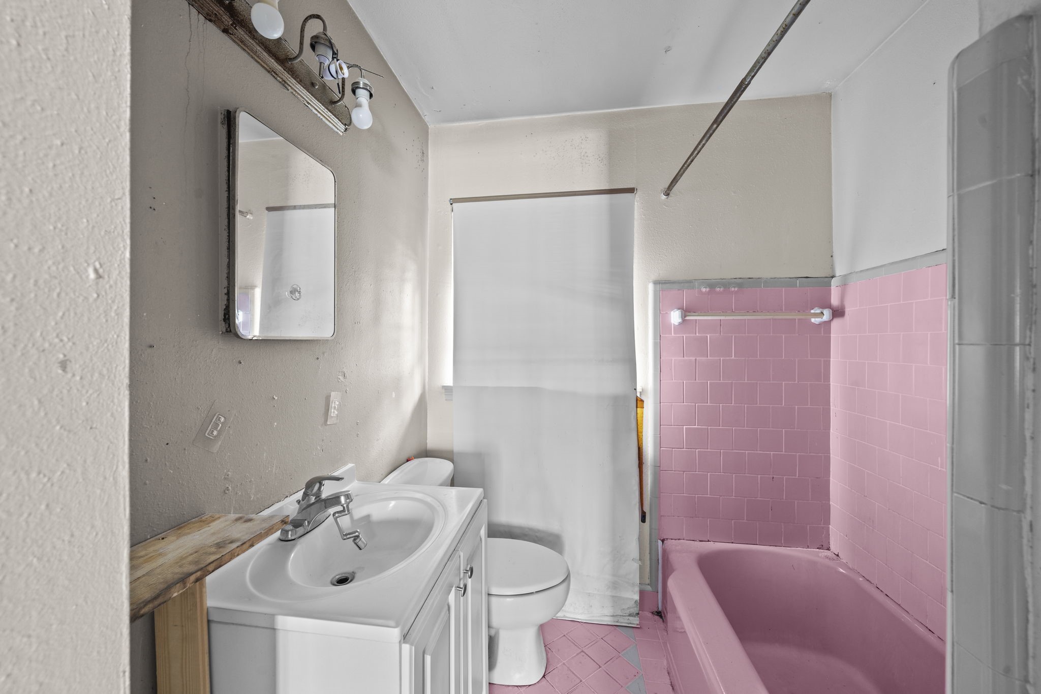 5810 Langley Road Houston, TX 77016 - Photo 17 of 20 The original bathroom shows the current layout, existing tub, and vintage pink finishes. It is a clear before-shot for a remodel with strong visual upside. Virtually staged.