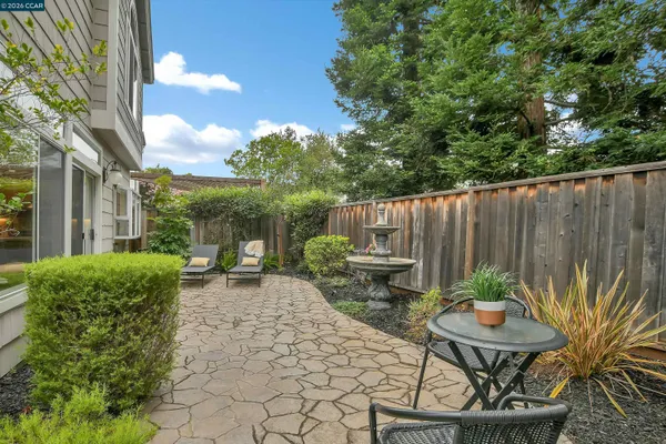 a view of a chair and table in backyard of the house