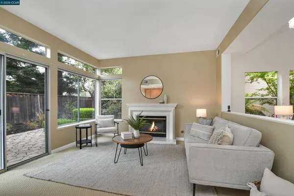 a living room with furniture a fireplace and a floor to ceiling window