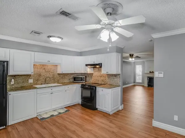 a kitchen with stainless steel appliances granite countertop a sink and cabinets