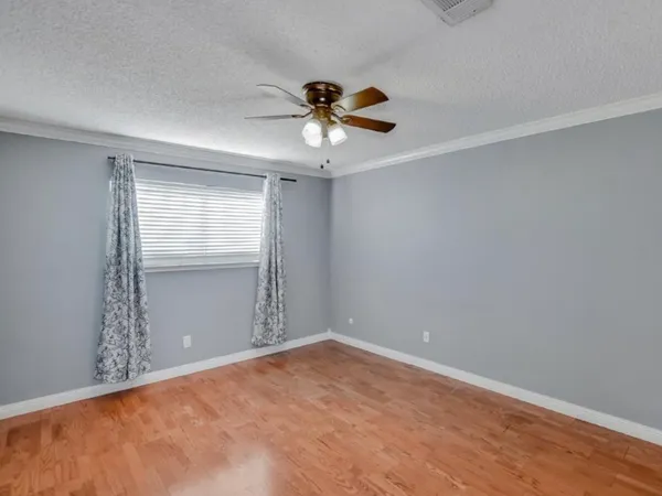 a view of an empty room with a ceiling fan and window
