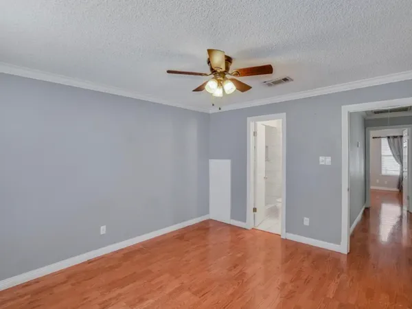 a view of a big room with wooden floor and a chandelier fan in a room