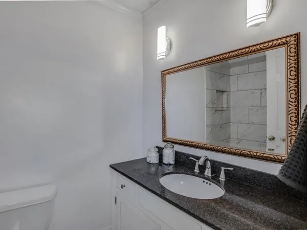 a bathroom with a granite countertop sink and a mirror