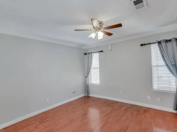 an empty room with windows and fan
