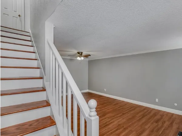 a view of staircase with wooden floor and white walls