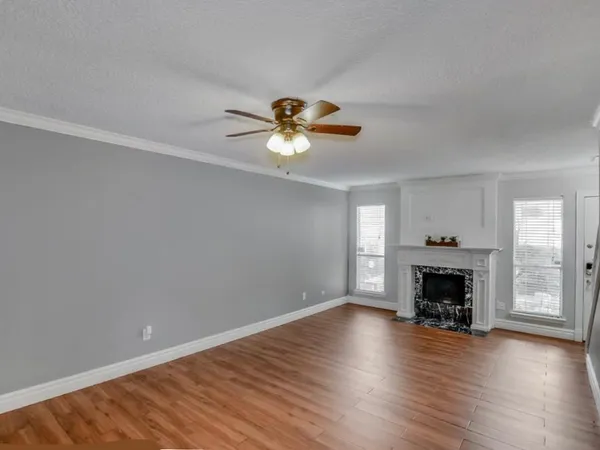 an empty room with fireplace wooden floor and windows
