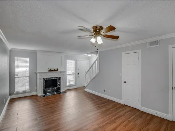 an empty room with wooden floor a fireplace and a window