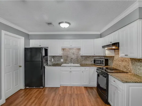 a kitchen with a refrigerator and a stove top oven