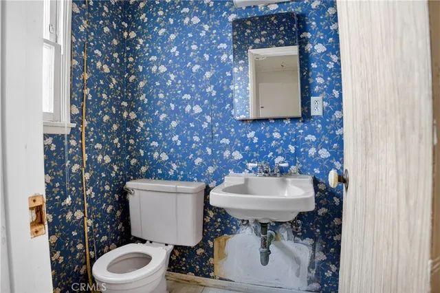 a bathroom with a toilet sink and mirror